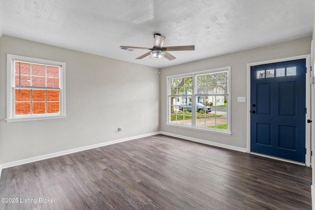 entryway featuring baseboards, ceiling fan, visible vents, and dark wood-type flooring