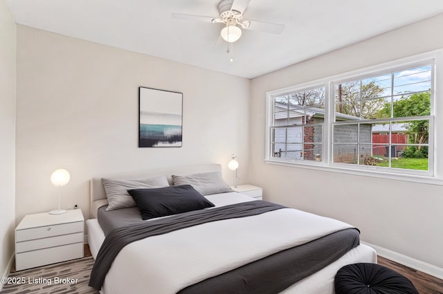 bedroom with baseboards, a ceiling fan, and wood finished floors
