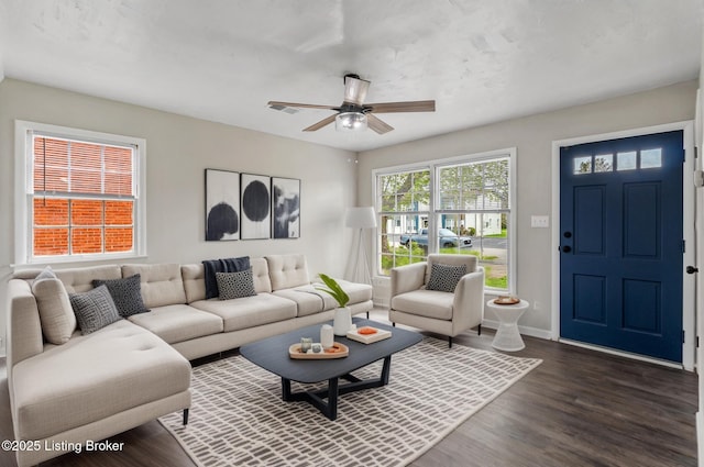 living room featuring baseboards, ceiling fan, dark wood finished floors, and visible vents