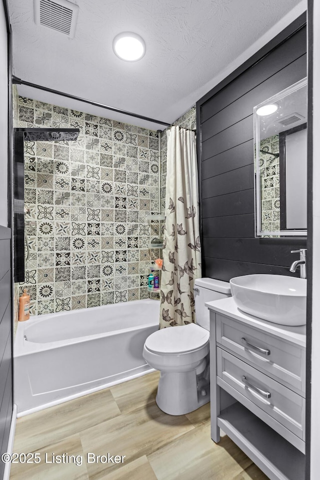 bathroom with wood finished floors, shower / tub combo with curtain, toilet, and vanity