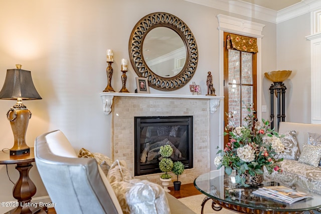 living room with ornamental molding, a brick fireplace, and wood finished floors