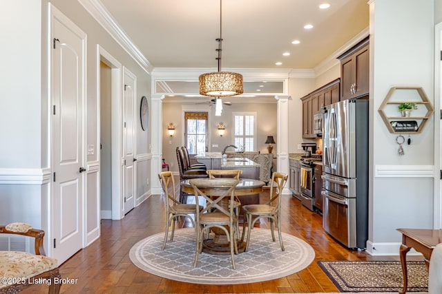 dining room featuring ornate columns, recessed lighting, dark wood-type flooring, and ornamental molding
