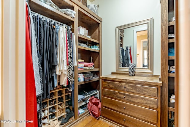 walk in closet with wood finished floors