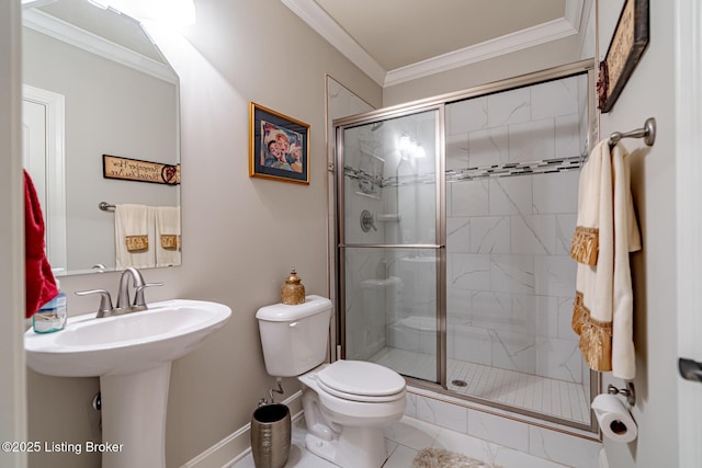 full bathroom with toilet, a sink, a stall shower, baseboards, and ornamental molding