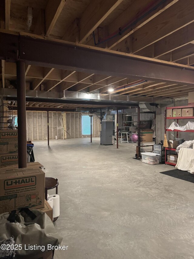unfinished basement featuring heating unit