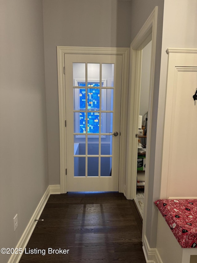 doorway with dark wood-style floors and baseboards