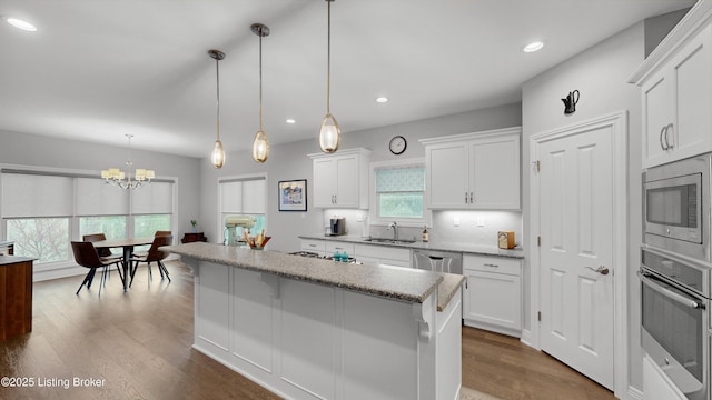 kitchen with white cabinetry, stainless steel appliances, an inviting chandelier, and a kitchen island