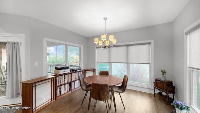 dining area with wood finished floors and a chandelier