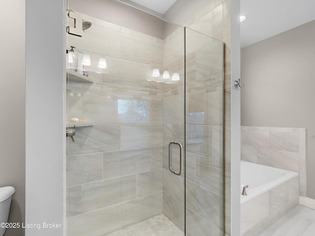 full bathroom featuring a stall shower, a garden tub, and toilet