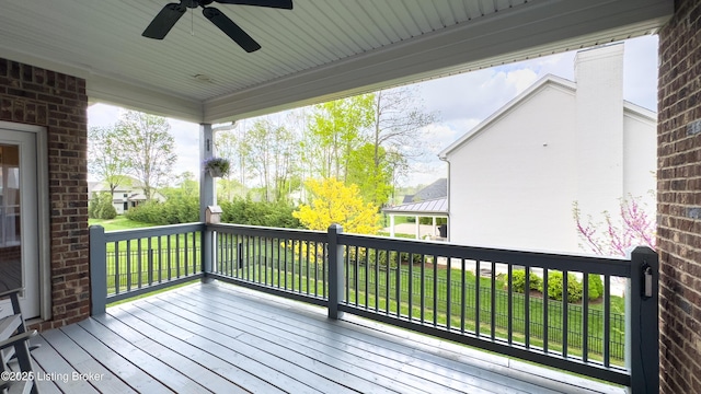 wooden deck with ceiling fan and a yard