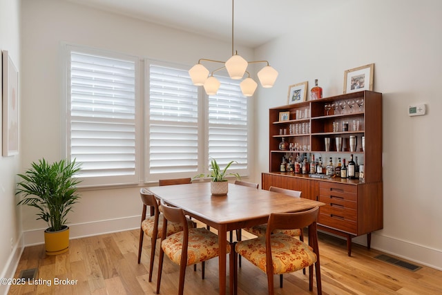 dining space featuring baseboards, visible vents, and light wood-type flooring