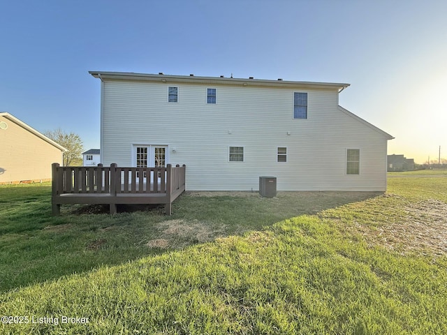 back of property with a lawn, a deck, and central AC unit