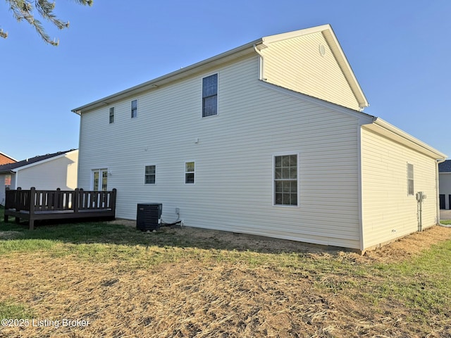 back of house with a deck, cooling unit, and a yard