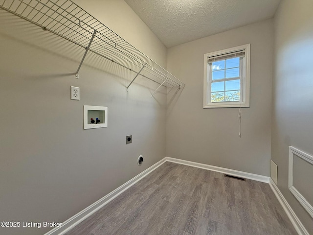 clothes washing area with wood finished floors, laundry area, hookup for an electric dryer, washer hookup, and visible vents