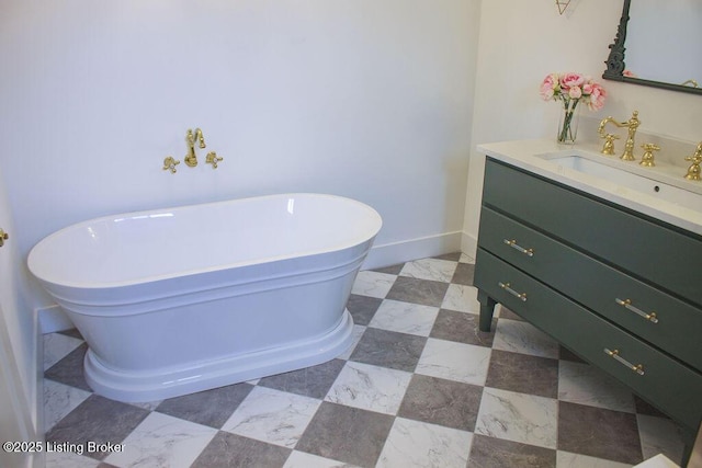 bathroom with a freestanding tub, baseboards, and vanity