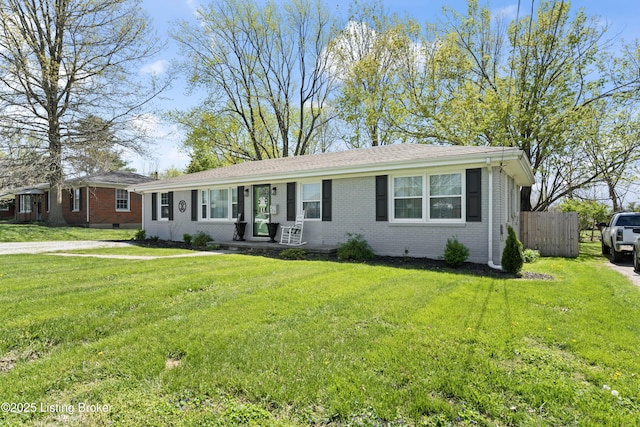 ranch-style house with a front lawn, brick siding, and fence