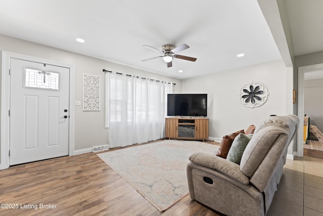 living area with recessed lighting, visible vents, a ceiling fan, and baseboards