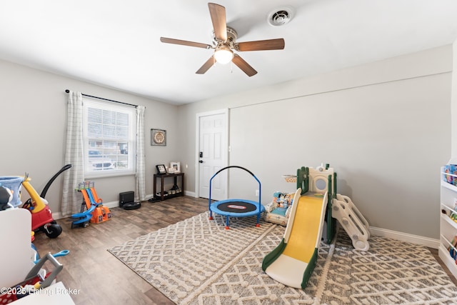 game room with ceiling fan, baseboards, wood finished floors, and visible vents