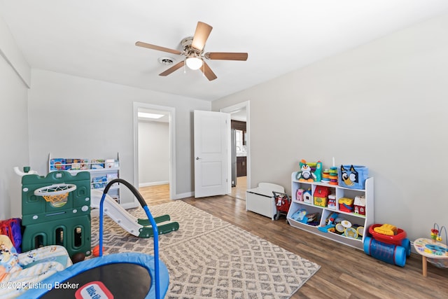 playroom featuring visible vents, baseboards, a ceiling fan, and wood finished floors