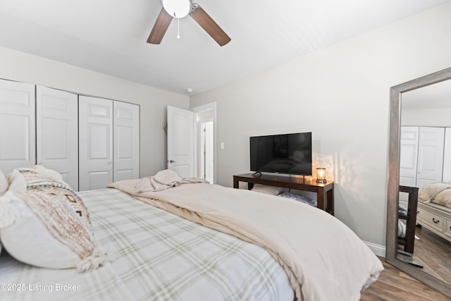 bedroom featuring baseboards, a ceiling fan, wood finished floors, and a closet