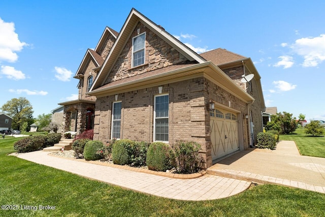 view of side of property featuring brick siding, stone siding, driveway, a garage, and a lawn