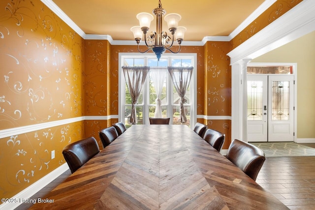dining space featuring an inviting chandelier, baseboards, hardwood / wood-style floors, and wallpapered walls
