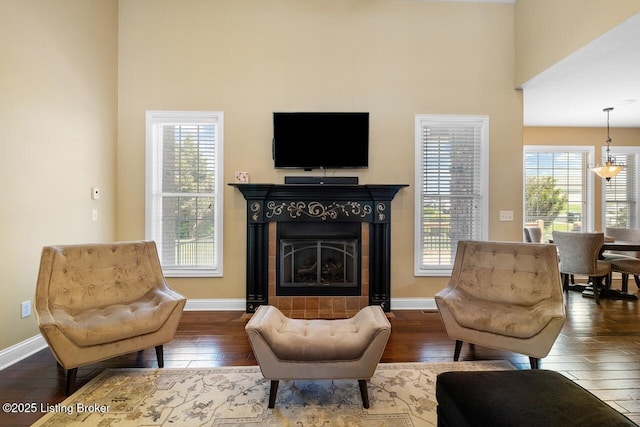 living area with baseboards, a high ceiling, and hardwood / wood-style flooring