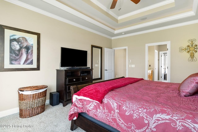 carpeted bedroom with a ceiling fan, a raised ceiling, connected bathroom, and crown molding