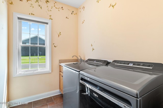 washroom with baseboards, a wealth of natural light, independent washer and dryer, and cabinet space
