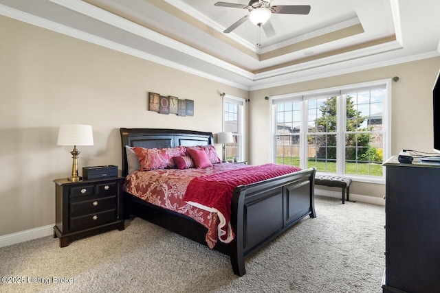 bedroom featuring light colored carpet, baseboards, a raised ceiling, and ornamental molding