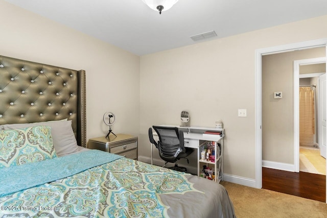 carpeted bedroom featuring baseboards and visible vents