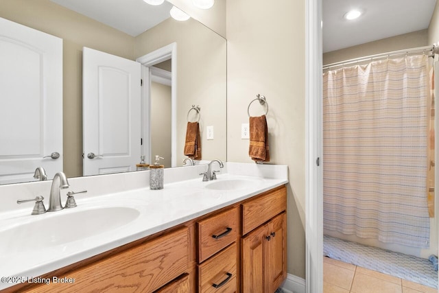 full bath with a sink, double vanity, and tile patterned floors