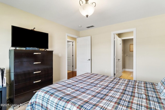 bedroom featuring baseboards and visible vents