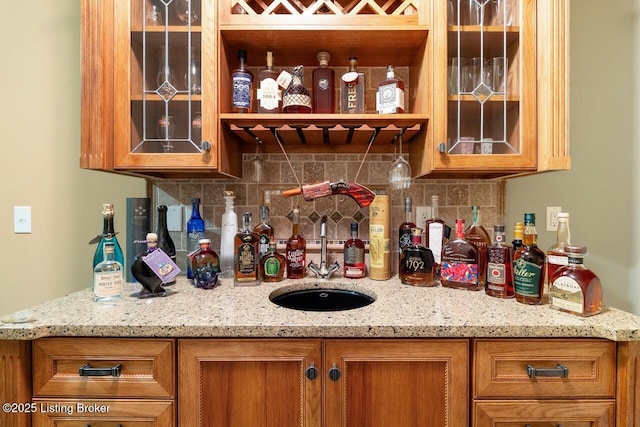 bar with wet bar, decorative backsplash, and a sink