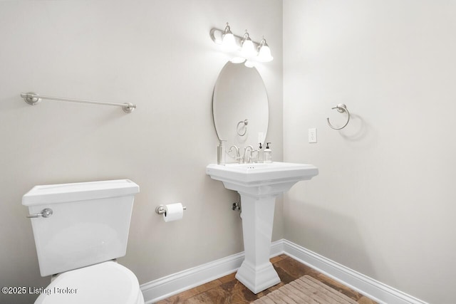 bathroom featuring toilet and baseboards