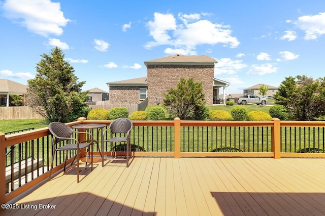 deck featuring a yard, fence, and a residential view