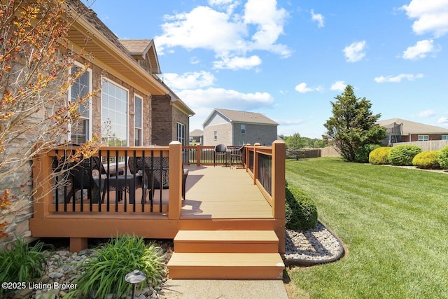 wooden terrace featuring a lawn