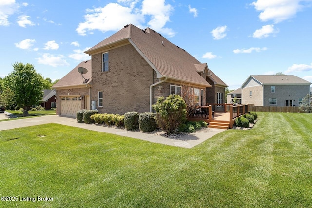 view of property exterior featuring roof with shingles, brick siding, concrete driveway, a wooden deck, and a lawn