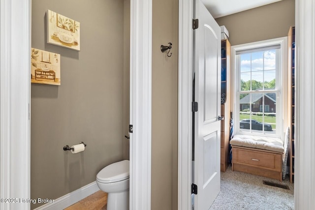bathroom with toilet, baseboards, and visible vents