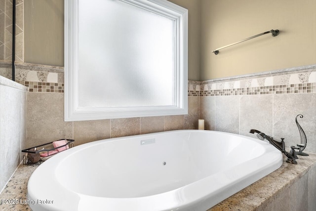 full bathroom with tile walls and a bathtub