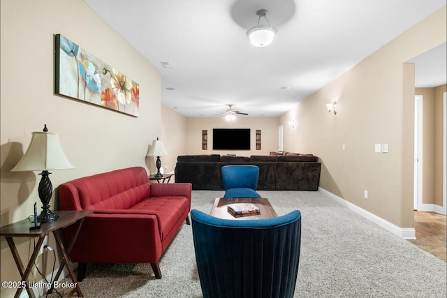 living room featuring ceiling fan, carpet, and baseboards