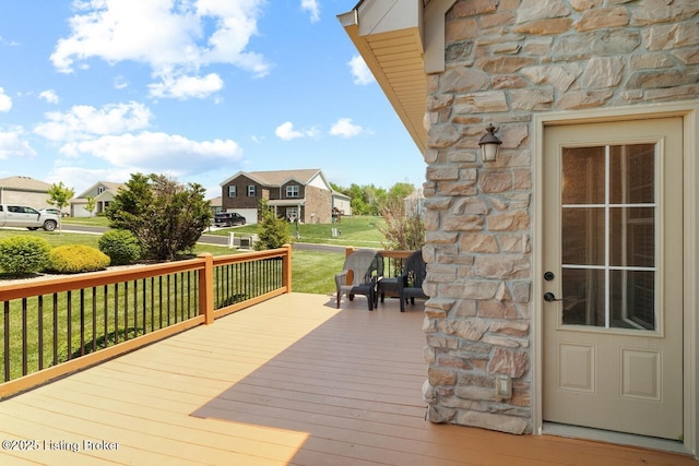 wooden deck featuring a residential view and a lawn