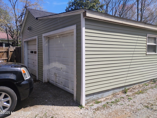 detached garage featuring fence