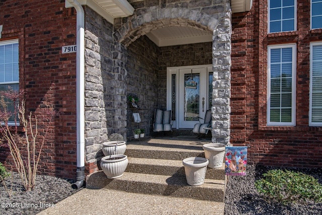 property entrance with brick siding and stone siding