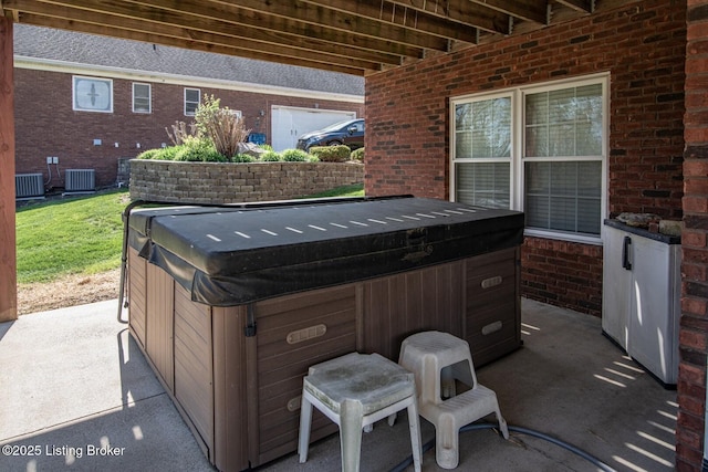 view of patio with central air condition unit and a hot tub