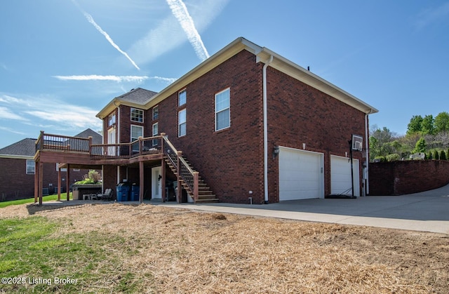 view of side of property with brick siding, an attached garage, a wooden deck, and stairway