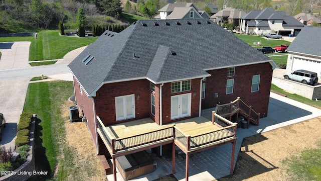 rear view of property featuring a wooden deck, french doors, brick siding, and central air condition unit