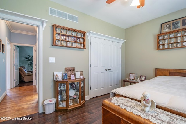 bedroom with a ceiling fan, wood finished floors, a closet, baseboards, and visible vents