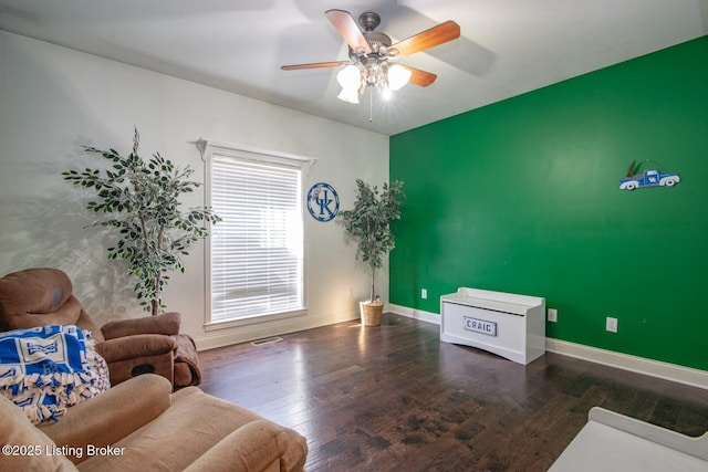sitting room featuring visible vents, baseboards, wood finished floors, and ceiling fan