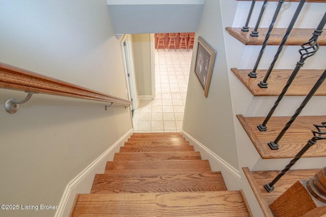 staircase with baseboards and tile patterned floors
